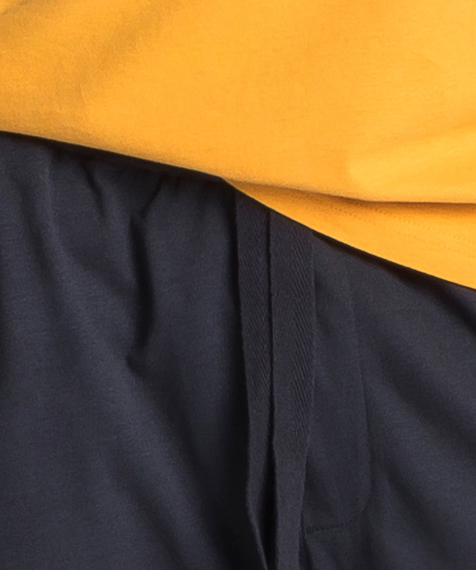 Piżama męska składa się z dwóch części: krótkich spodenek (szortów) w kolorze grafitowym oraz gładkiej koszulki w kolorze żółtym z napisem ATLANTIC #1