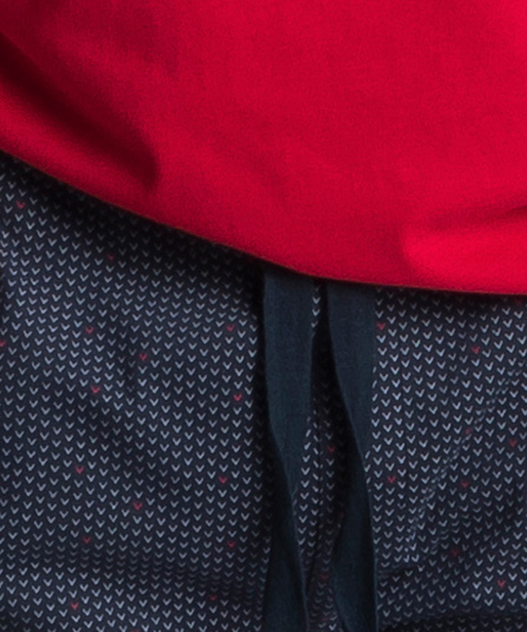 W skład piżamy męskiej wchodzą dwie części: długie spodnie w kolorze granatowym ozdobione niewielkich rozmiarów graficznymi wzorkami, oraz gładka koszulka z krótkimi rękawami, w kolorze czerwonym #2