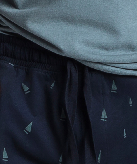 W skład męskiej piżamy wchodzą dwie części: długie spodnie w kolorze granatowym, ozdobione niewielkich rozmiarów wzorkami w zielone żaglówki oraz zielona bluza z długimi rękawami i widocznym logo marki po lewej stronie #2